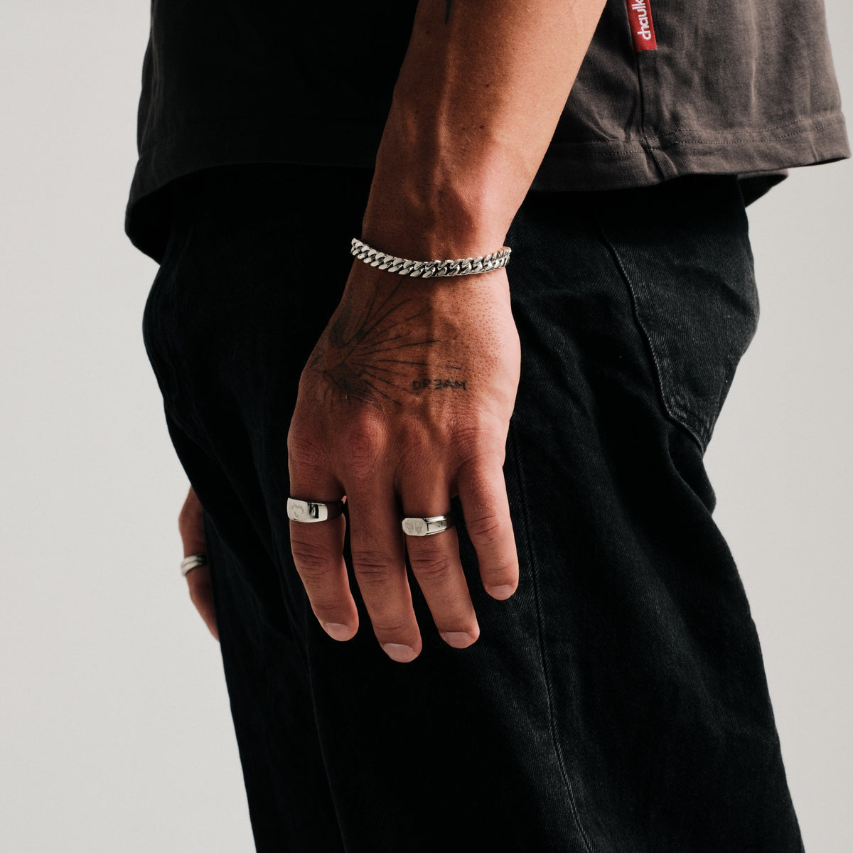 Men's Ember Ring in 316L stainless steel, silver finish, worn on his left index finger, hand hanging by his side