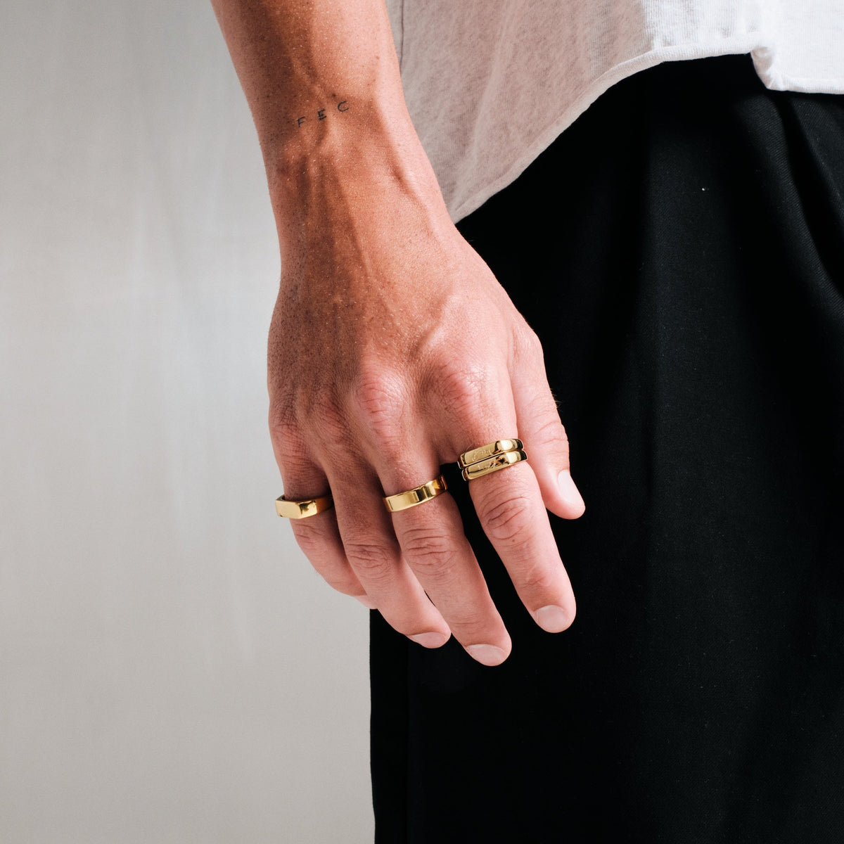 Men's Gold Genesis Ring in 18k gold infused stainless steel, worn on the little finger, hand hanging at his side