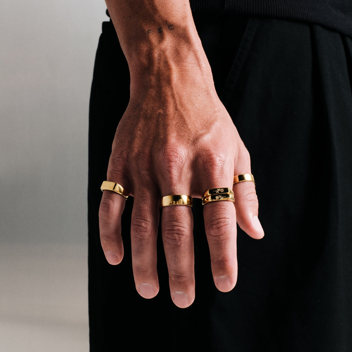 Men's Gold Genesis Ring in 18k gold infused stainless steel, worn on the little finger, hand hanging at his side
