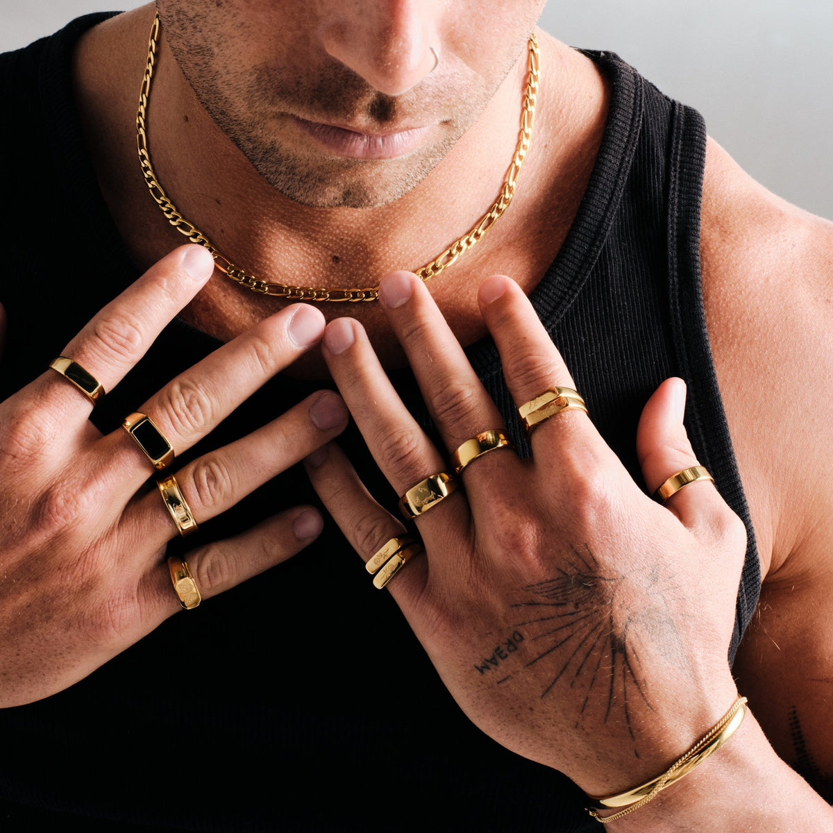 Men's Gold Onyx Ring in 18k gold infused stainless steel, in a stack, hands on his chest, black singlet
