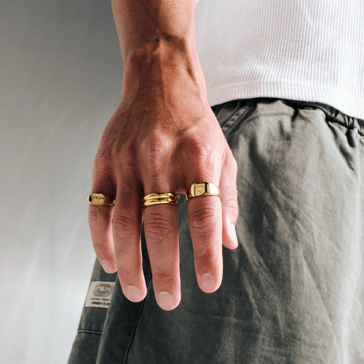 Men's Gold Revival Ring in 18k gold infused stainless steel, worn on the little finger, hand hanging at his side