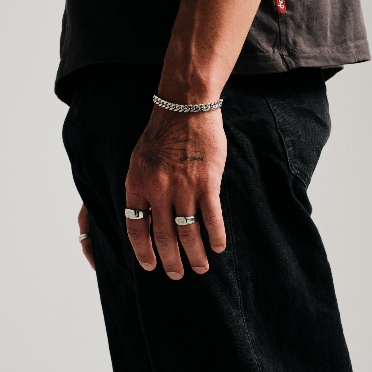 Men's Revival Ring in 316L stainless steel, silver finish, worn on his left ring finger, hand hanging at his side