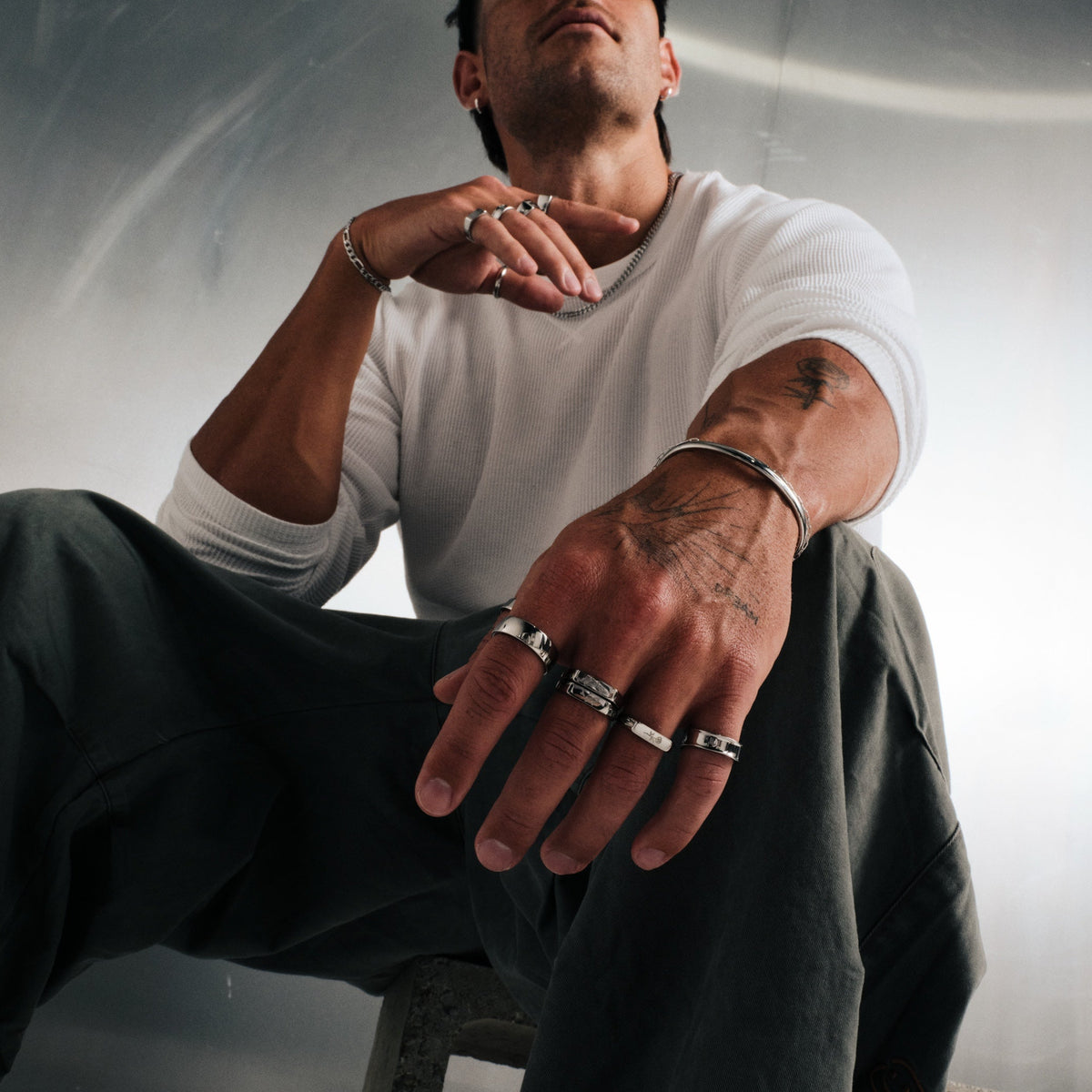Men's Rosa II Ring in 316L stainless steel, silver finish, worn on the ring finger, white waffle tee, olive pants