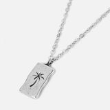 Billie Jo's sterling silver Paradiso Pendant, featuring a rustic, rectangular tag with a dark palm tree engraving for a modern, coastal aesthetic.