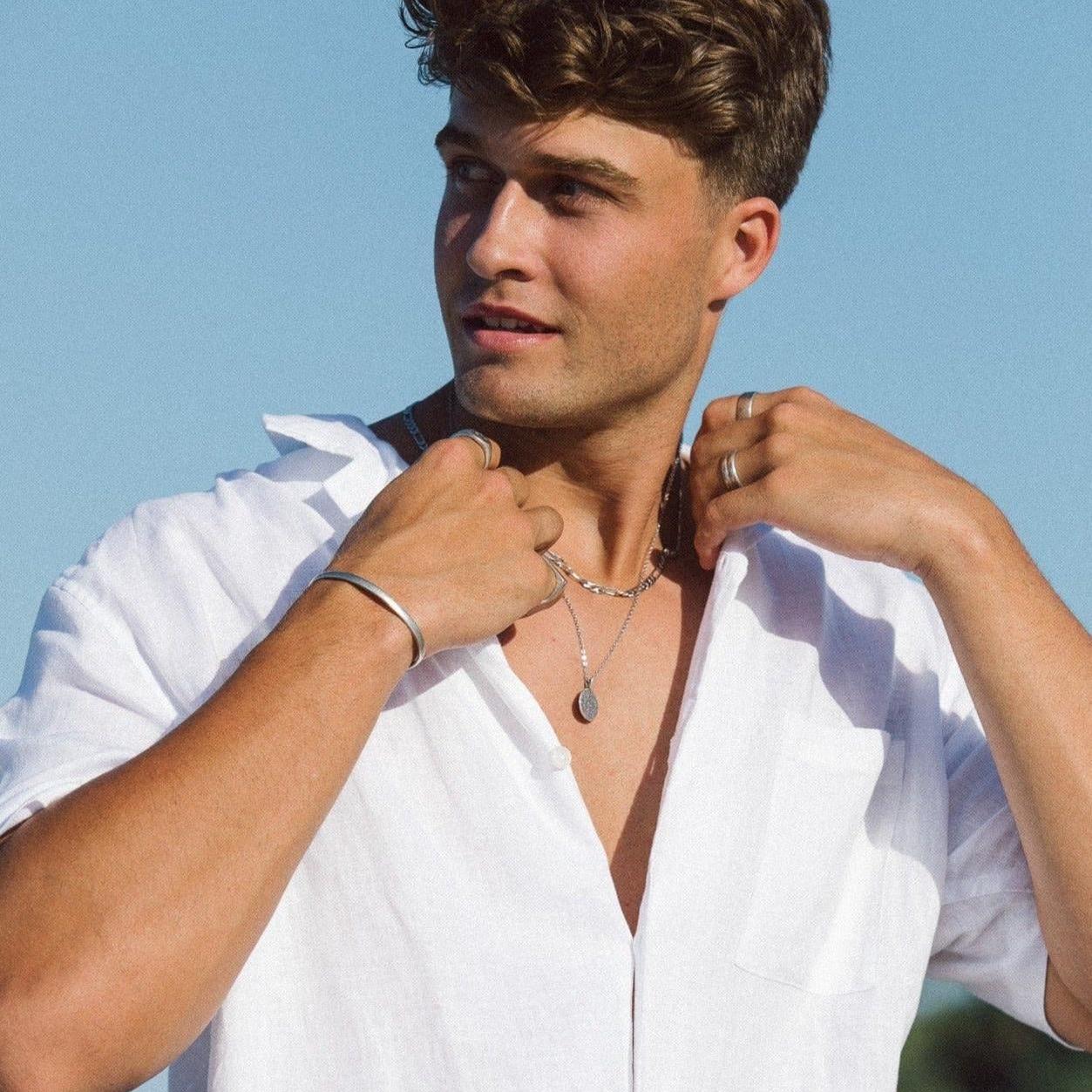 A stylish man wears the Billie Jo Drifter Cuff with a white shirt and layered necklaces, showcasing a modern, masculine Australian jewellery style.