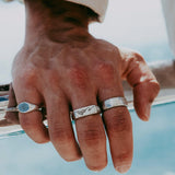 The sterling silver Union Ring by Billie Jo, shown on a man's hand and styled with other rings for a modern, layered look. Australian men's jewellery.