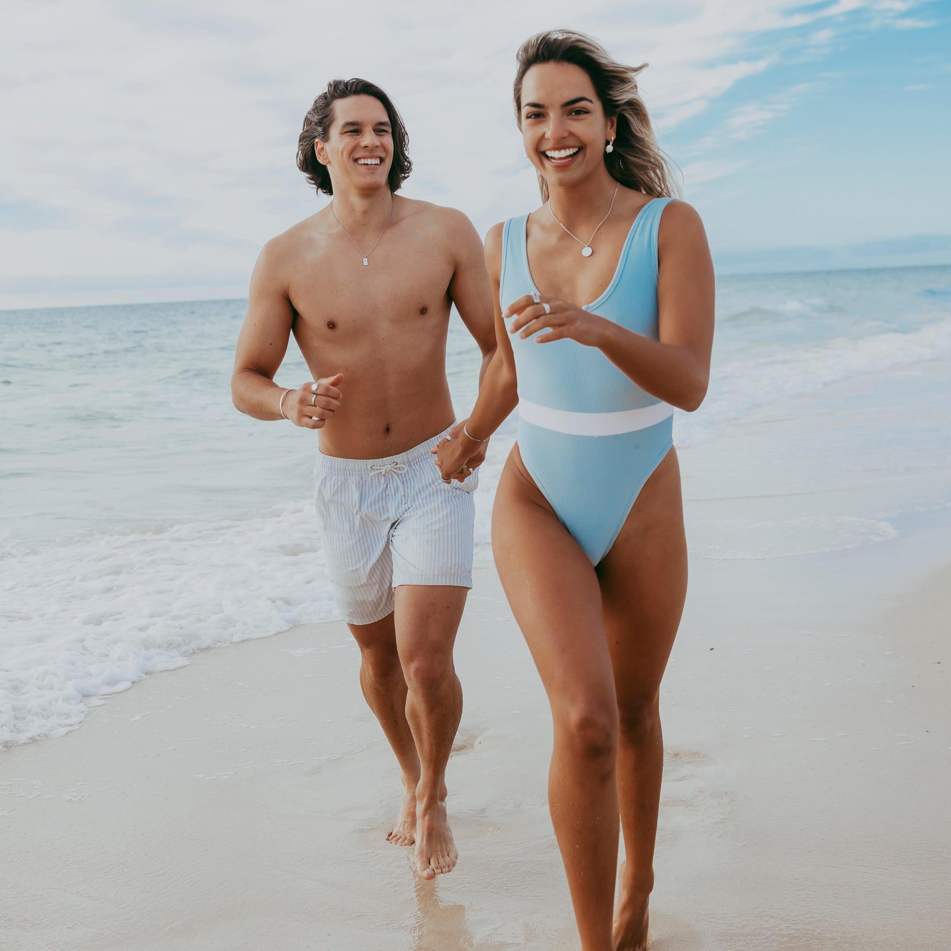 A happy couple on the beach, the man wearing the Billie Jo Untold Pendant, capturing a carefree, coastal lifestyle.