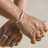 A detailed close-up of the Billie Jo Drifter Cuff on a man's wrist, highlighting the smooth, curved design and sterling silver material.